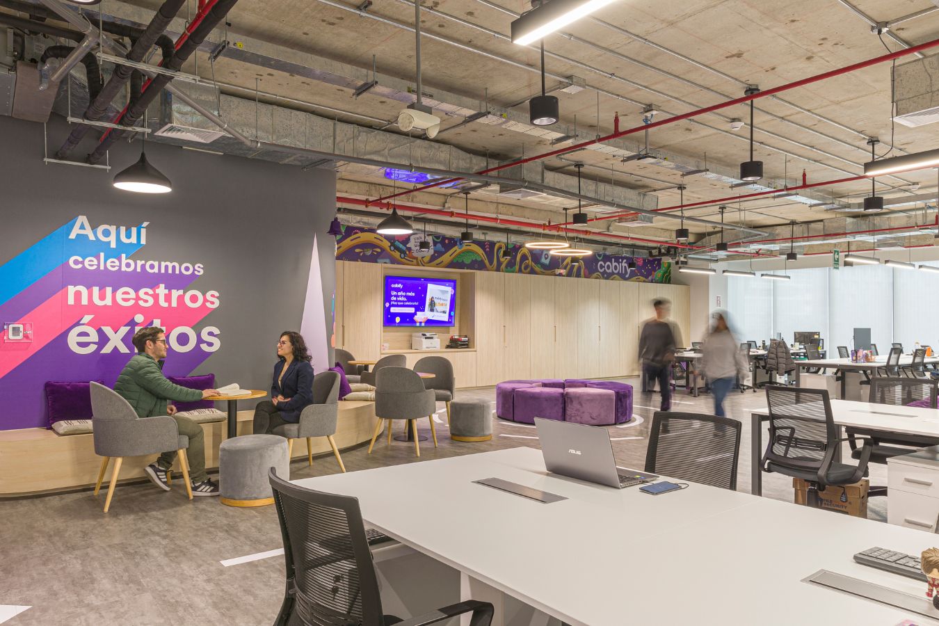 Cabify Offices - Team collaboration area with large communal table and colorful branding - Contract Workplaces.jpg